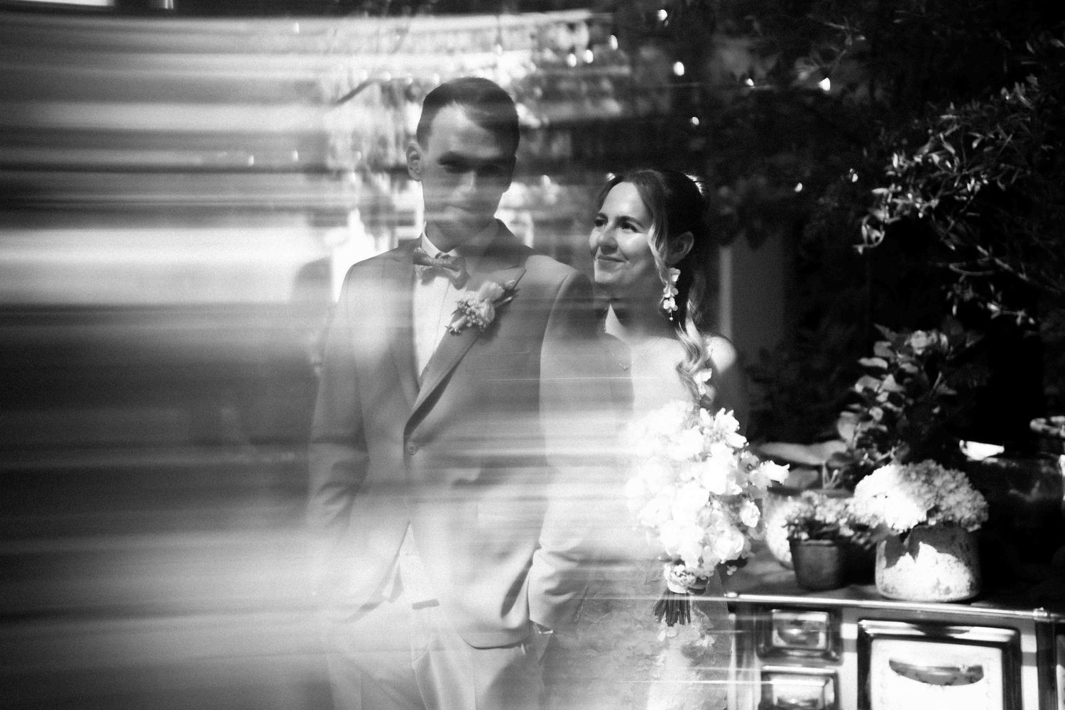 Artistic black and white wedding photograph with motion blur effects creating a dreamy atmosphere.