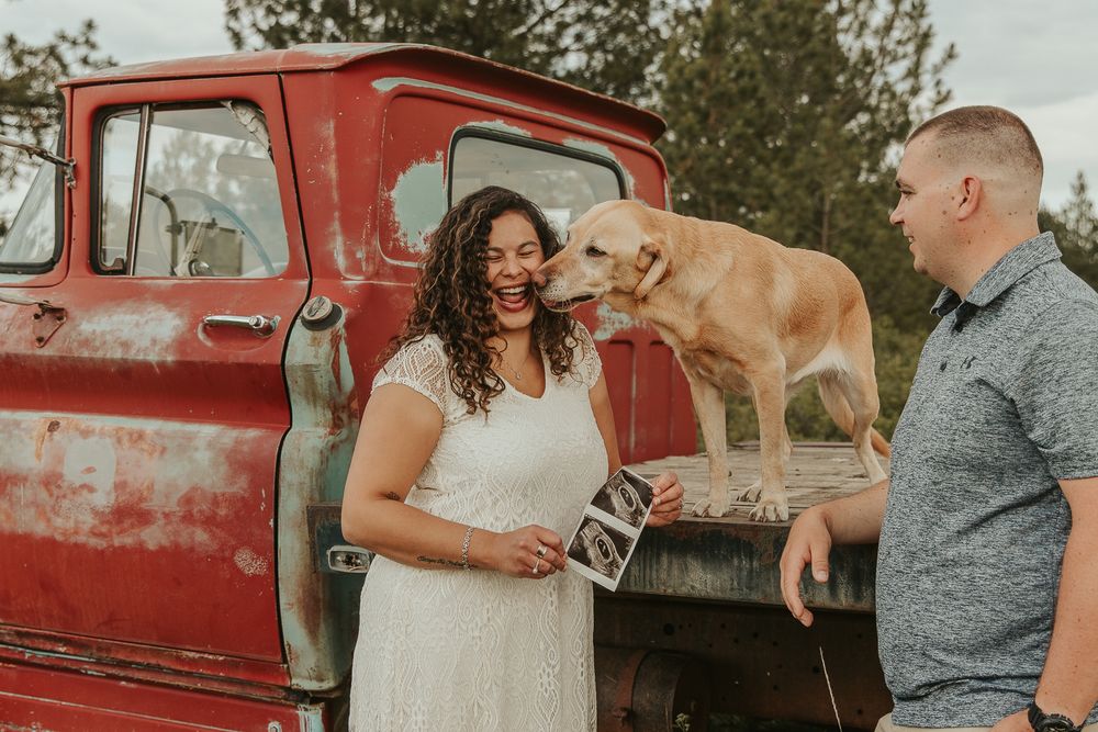 Celebrating gender reveal with pink powder smoke bombs in open field at outdoor photography venue in Spokane, Spokane family photographer
