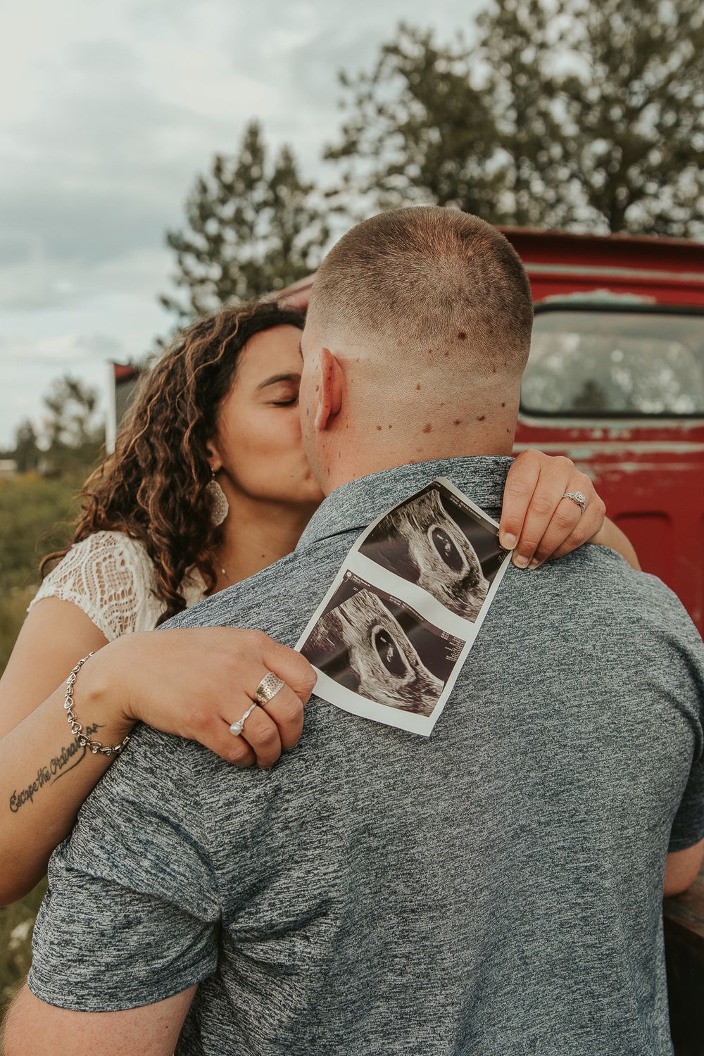 Celebrating gender reveal with pink powder smoke bombs in open field at outdoor photography venue in Spokane, Spokane family photographer