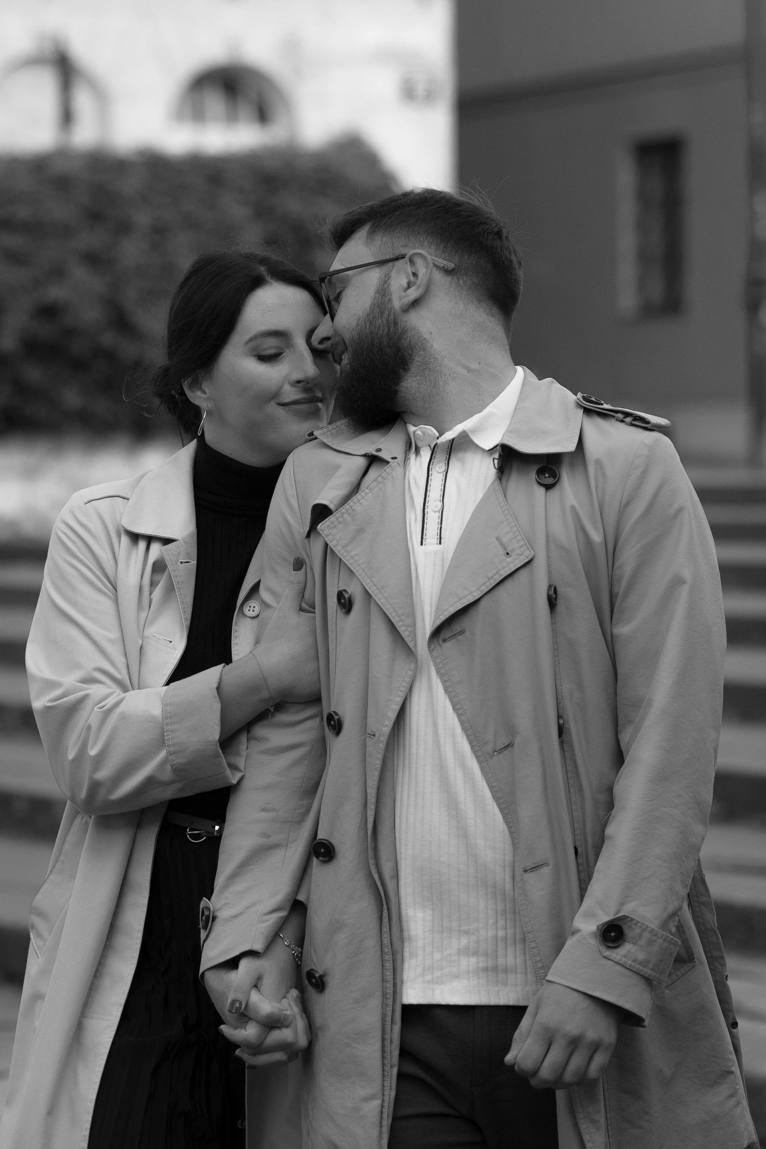 A black and white photo collage shows a romantic couple in light coats embracing in various candid moments.