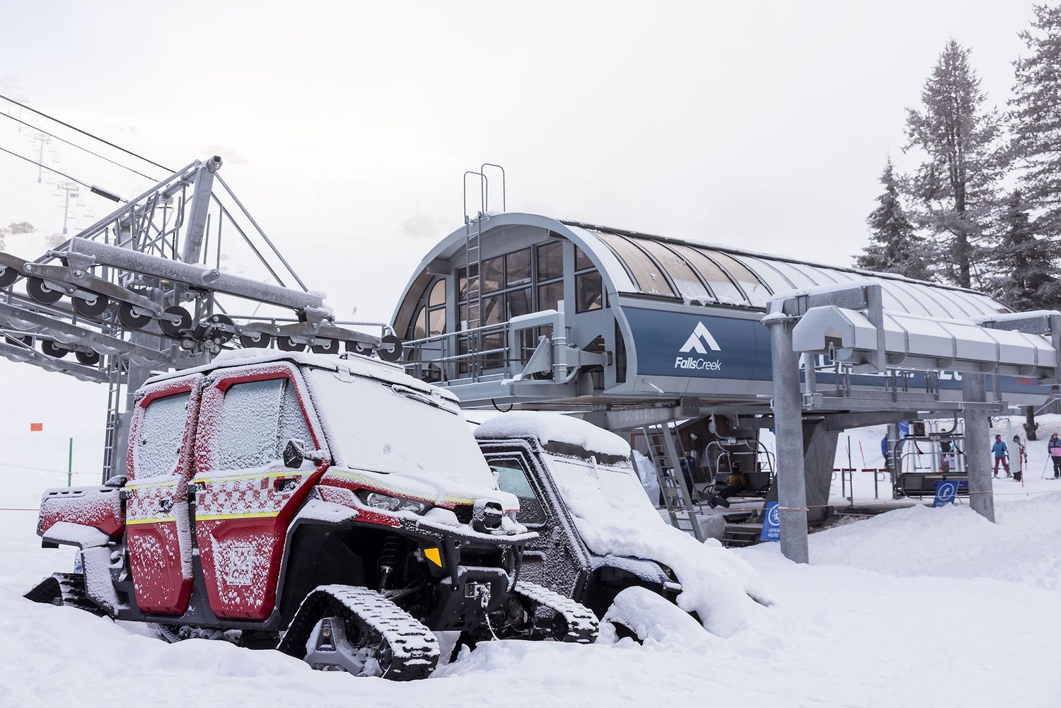 A snowcat vehicle at the modern Eagle ski lift station covered in fresh snow at a winter Falls Creek resort.