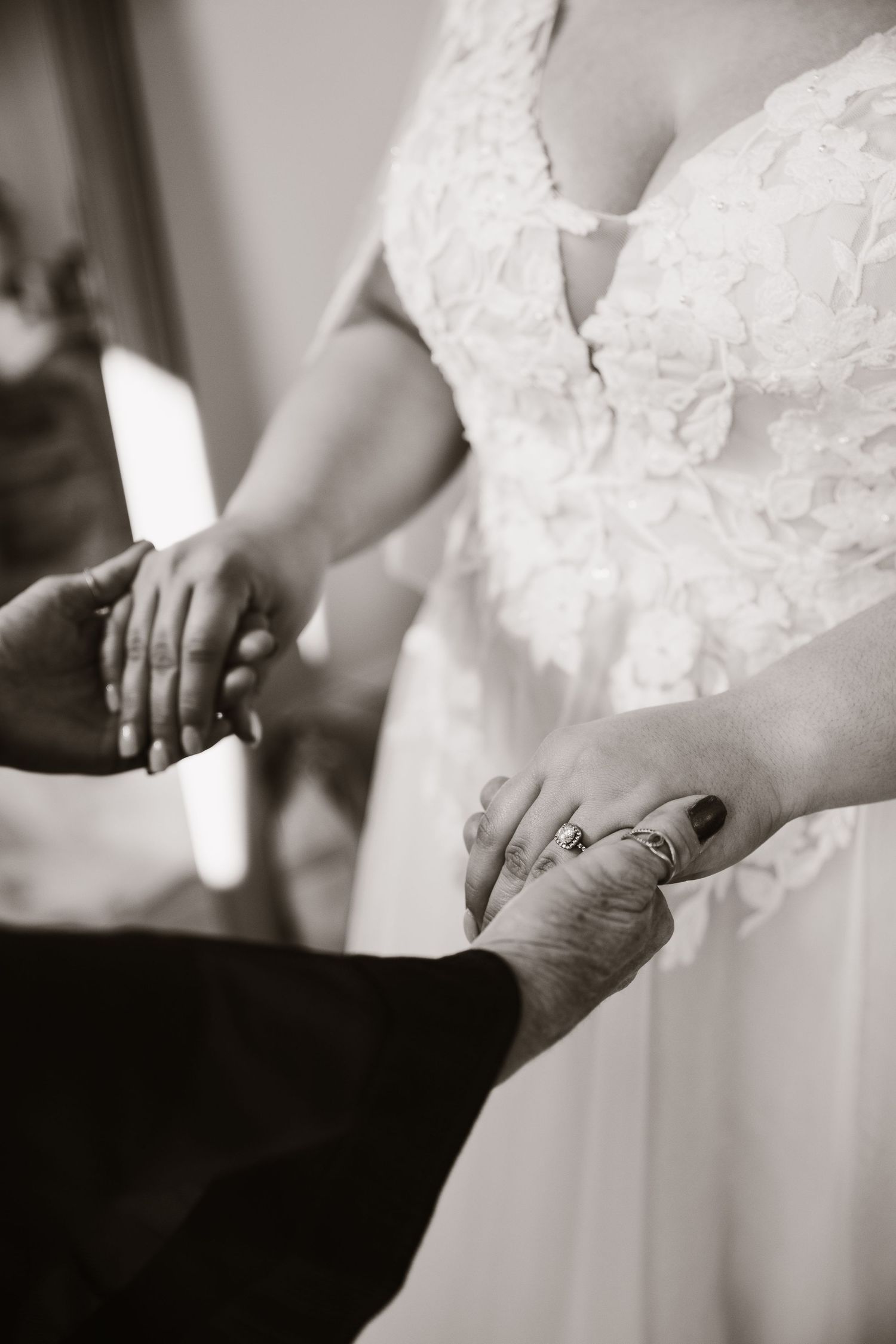 Black and white detail shots of a bride's lace wedding dress.