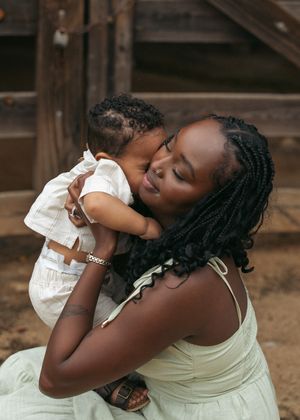 An intimate moment of affection between parent and child against a rustic wooden background.