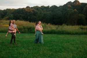 Family gathering in a grassy field during golden hour.