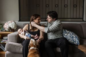 A couple relaxes together on a couch with their golden retriever dog in a series of intimate home photos.