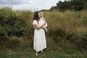A series of outdoor photos showing someone in a white dress running through a grassy meadow on a cloudy day.