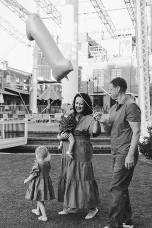 Family enjoying a day out at an outdoor entertainment venue with industrial architecture and green space.