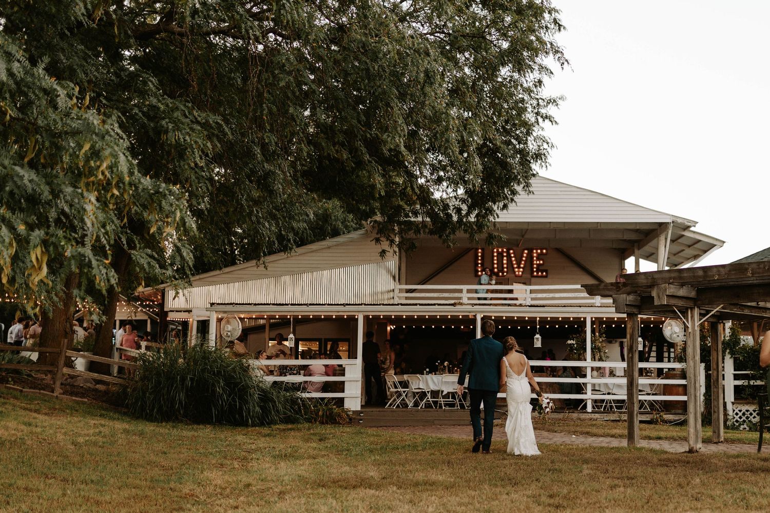A rustic outdoor wedding reception venue with string lights at Live Farms.