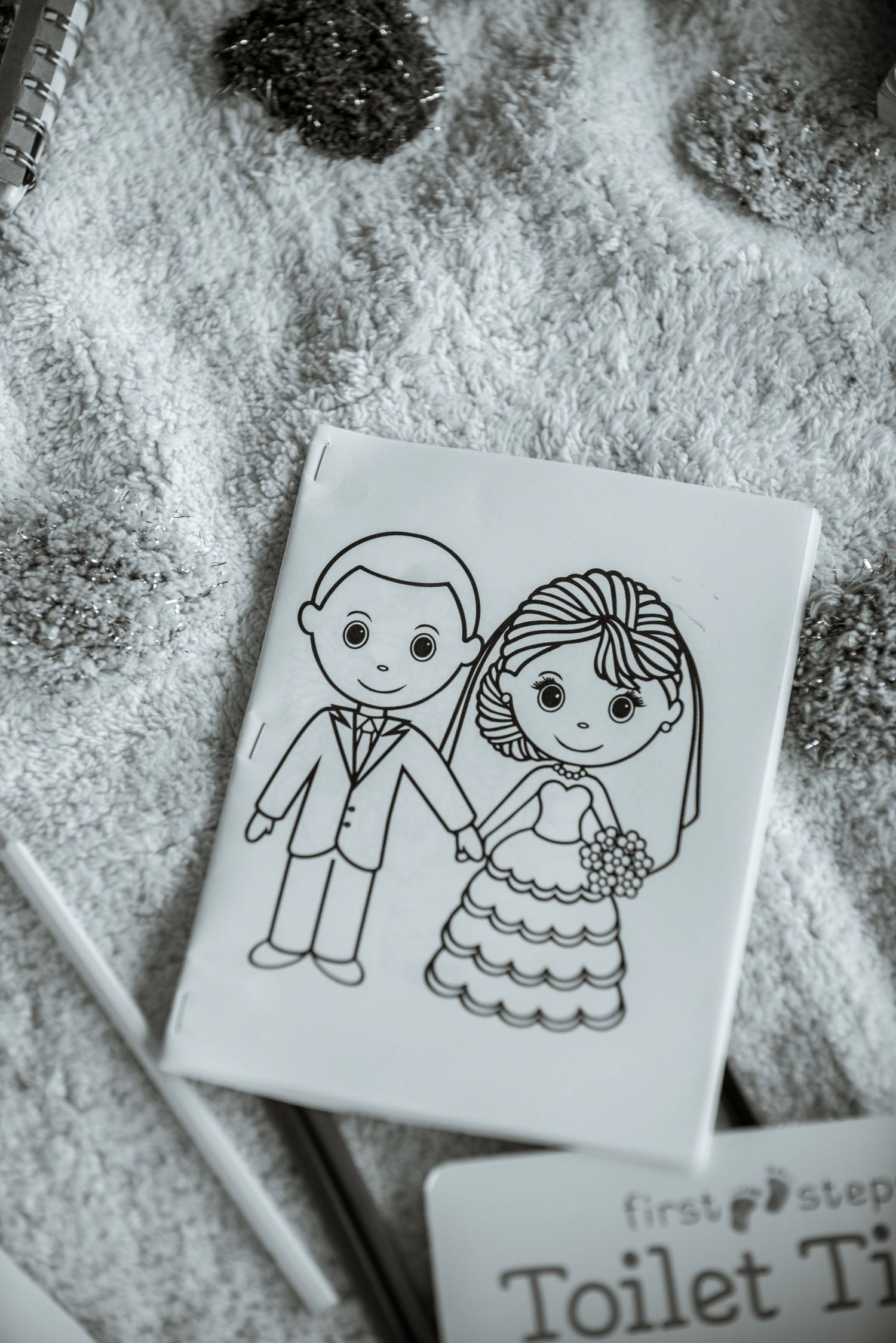 A cute cartoon drawing of a bride and groom on a white card against a textured background.