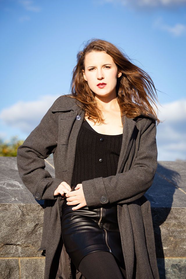 a woman in black top posing with her hand on the hips