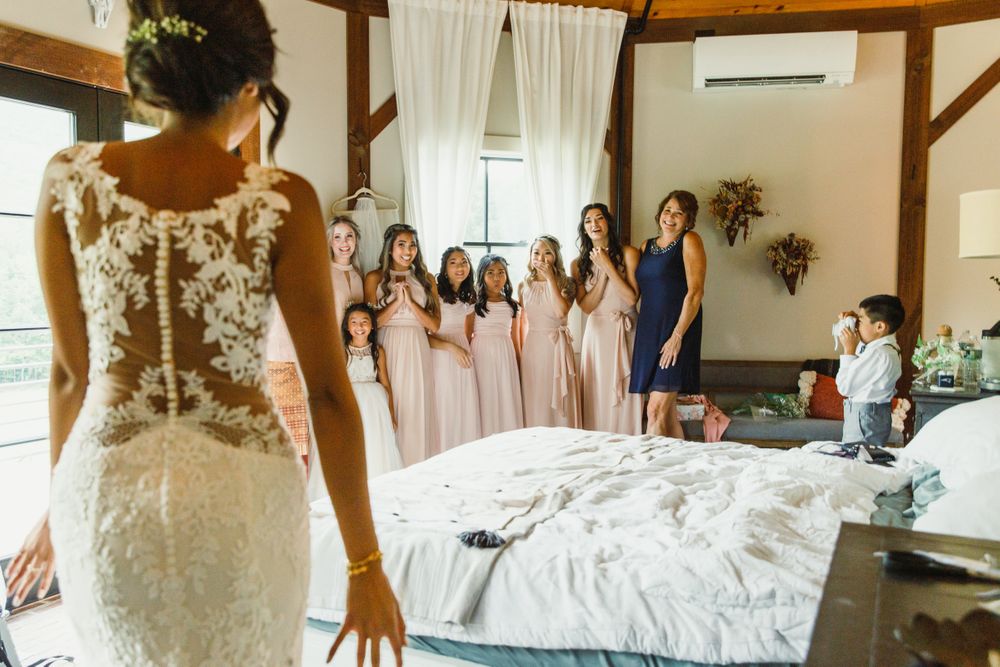 Wedding dress reveal moment in rustic room with natural lighting.