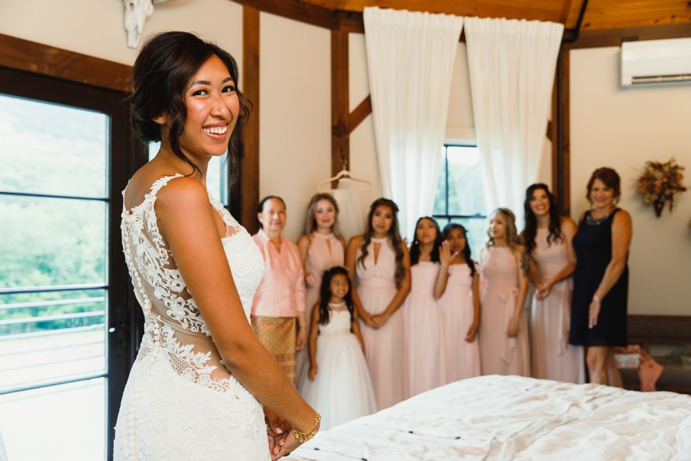 Joyful wedding preparation scene with bridesmaids in light pink dresses.