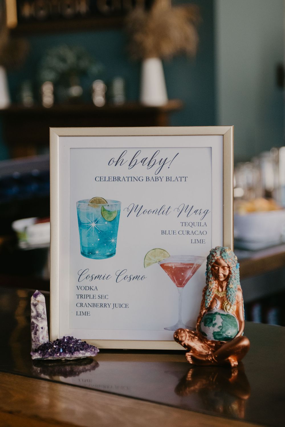 Baby shower cocktail menu sign for Baby Blatt featuring Mocktail Mary and Cosmic Cosmo drink recipes with watercolor illustrations.
