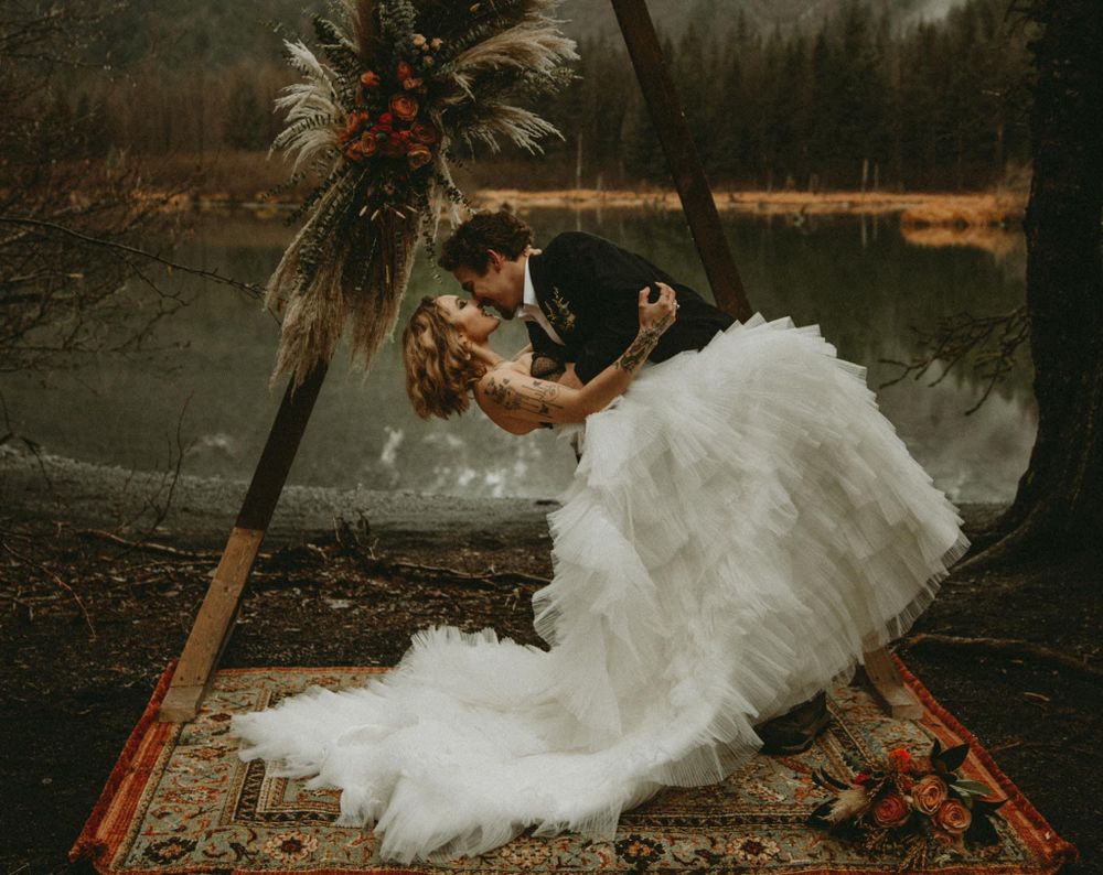 moody elopement photos a couple kissing in a rainy forest in Minnesota
