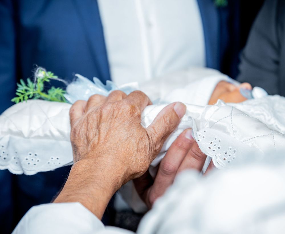 Close-up of hands touching during a wedding ceremony with white lace details.