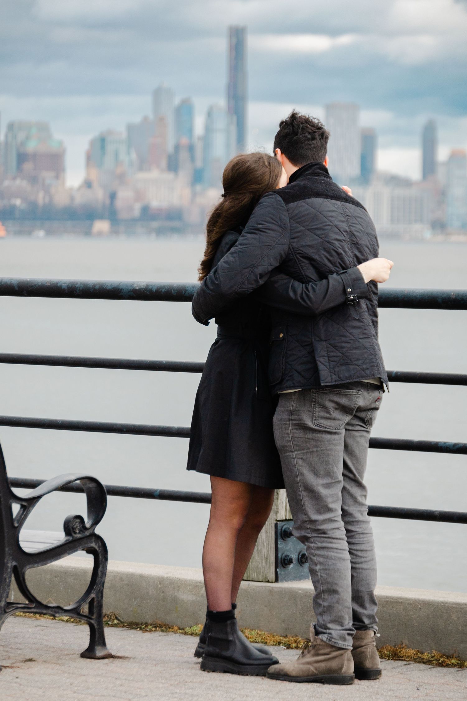 Couple hugging after surprise Liberty State Park proposal in NYC