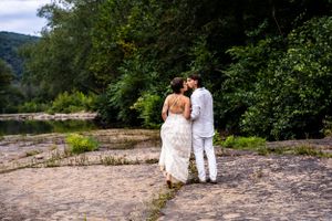 A newlywed couple kiss in a scenic outdoor location