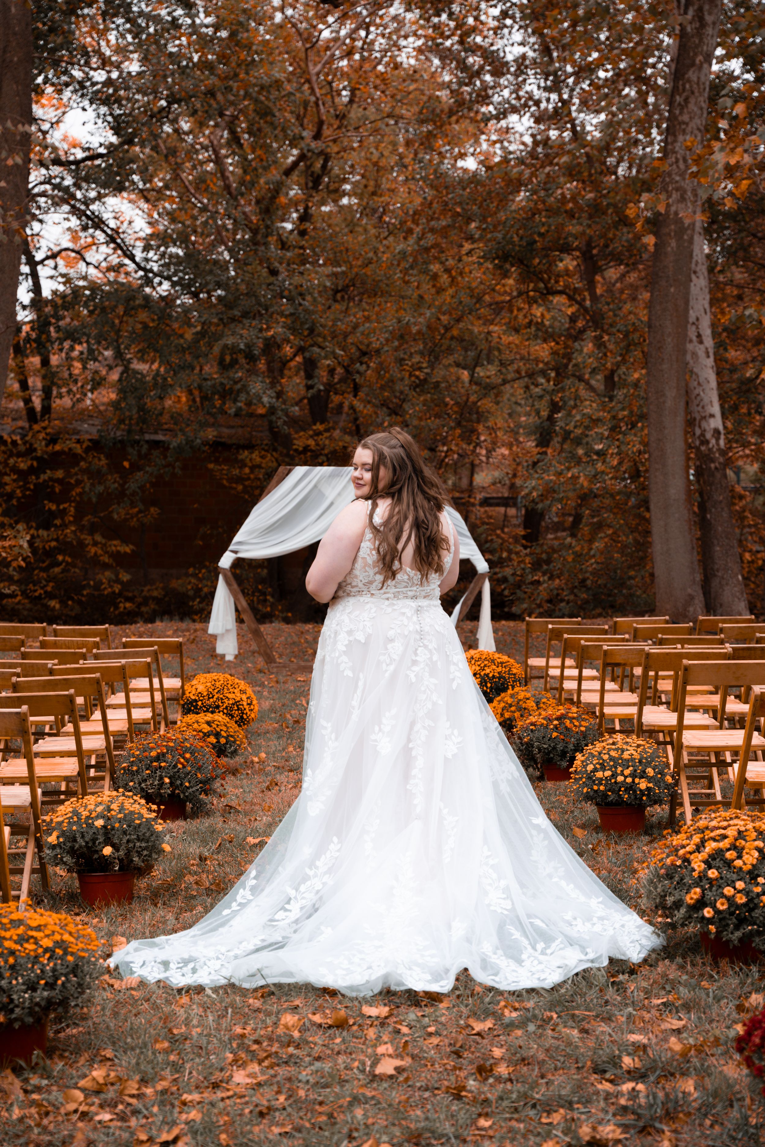 A bride shows off her dress in the fall