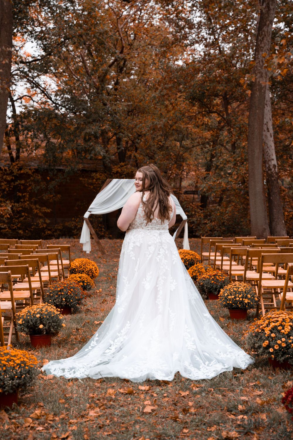 A bride shows off her dress in the fall