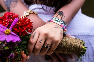 A woman's hand with a wedding ring, holding a bouquet