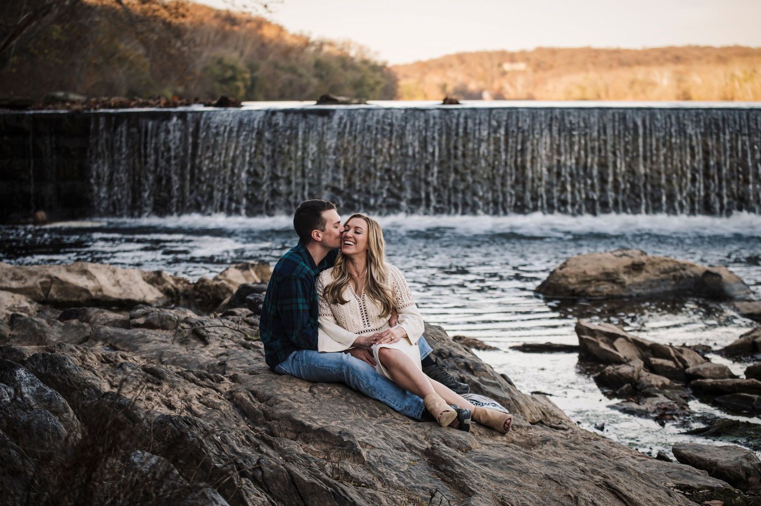 Romantic engagement photos at a waterfall with dramatic natural scenery.