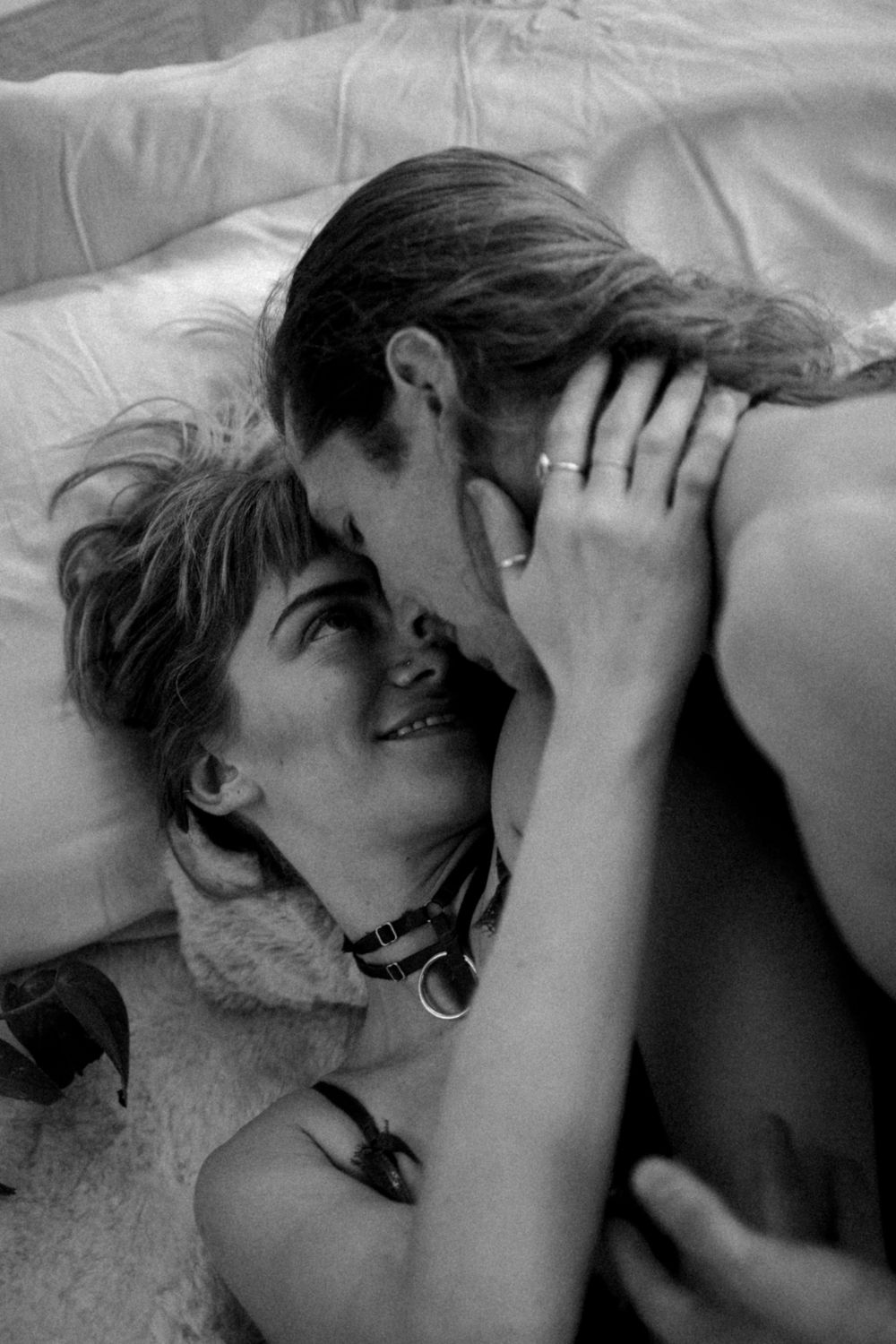 Black and white intimate portrait on white bedding.