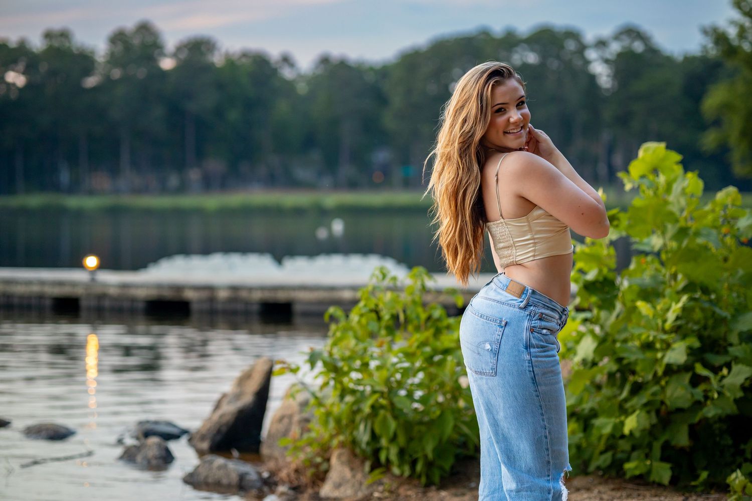 Sunset fashion photography by lake with casual denim outfit.
