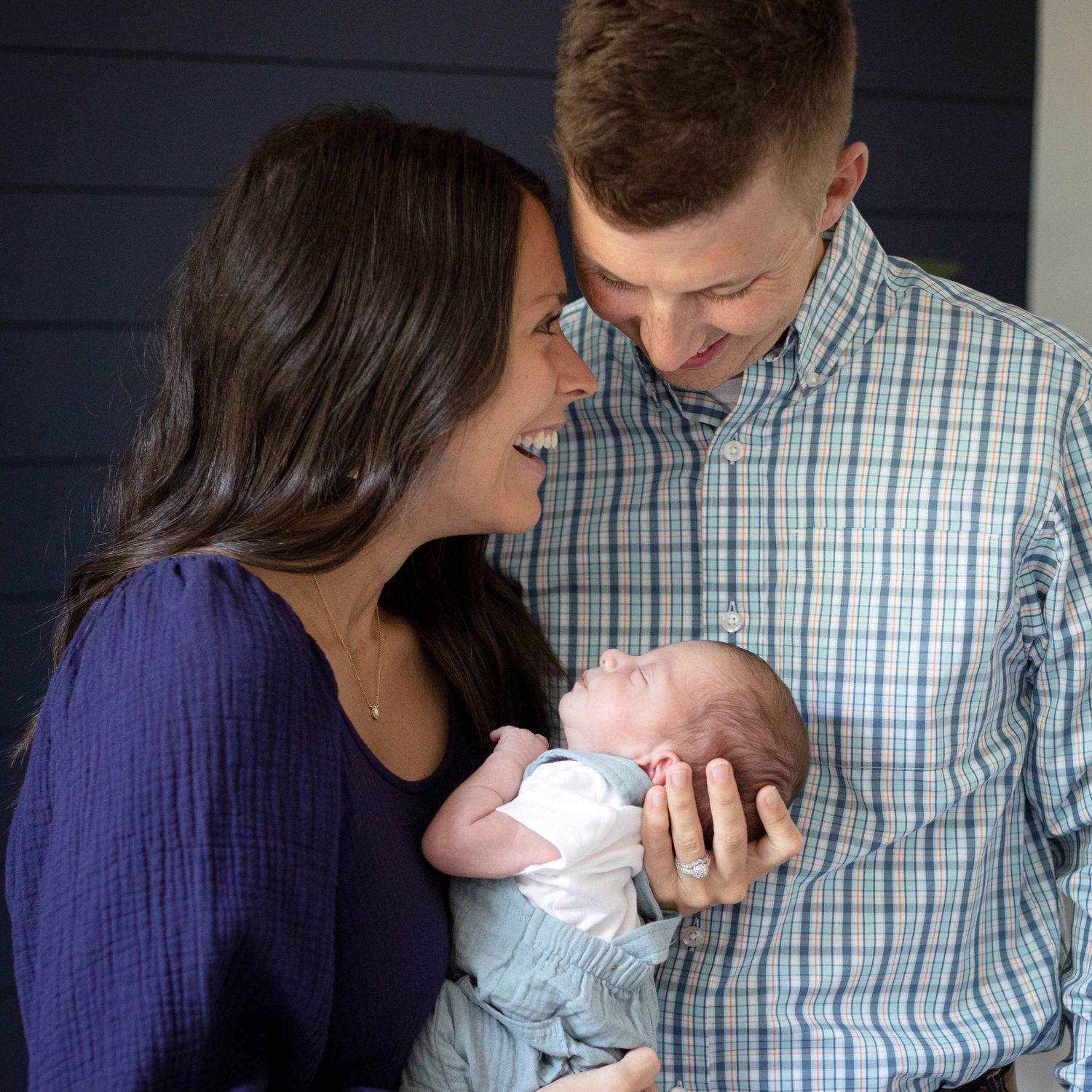 parents with newborn baby in blue bedroom by victoria leigh photography