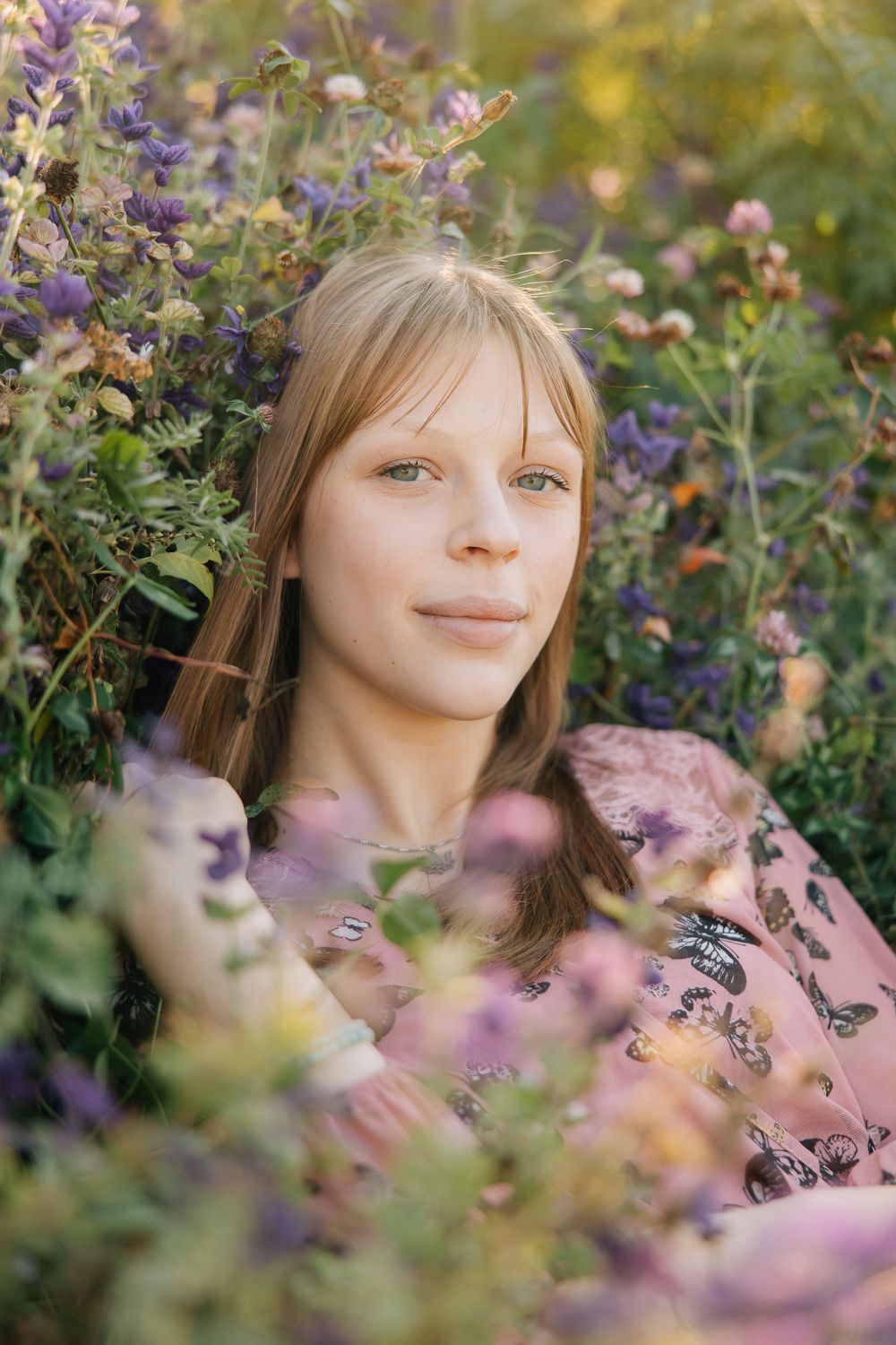 Portrait surrounded by purple and pink wildflowers in garden setting.