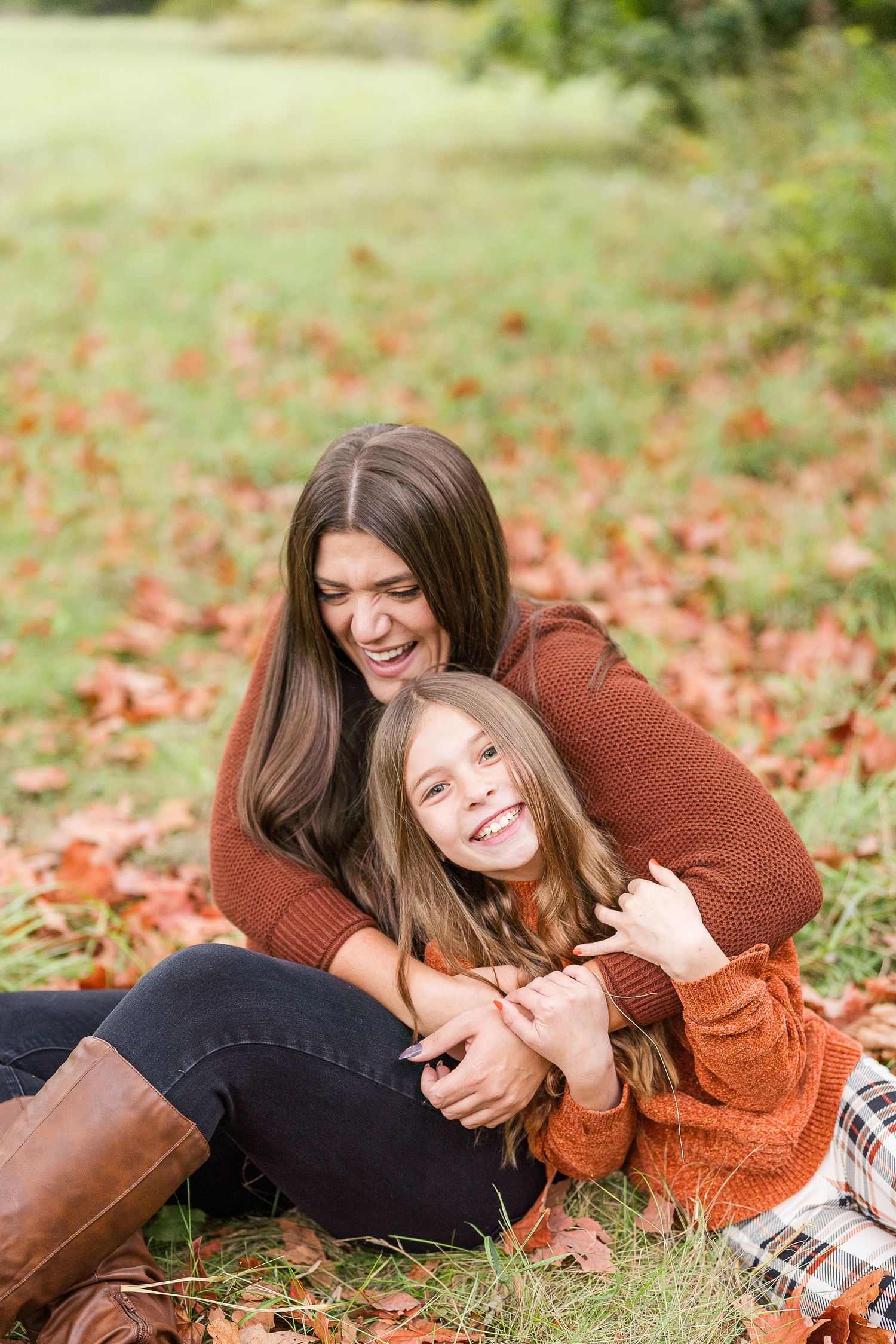 aunt and niece photoshoot at busse woods. sitting in a field posing taken by a milwaukee wedding photographer