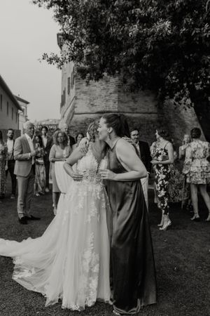 A tender moment between wedding guests during an outdoor celebration.