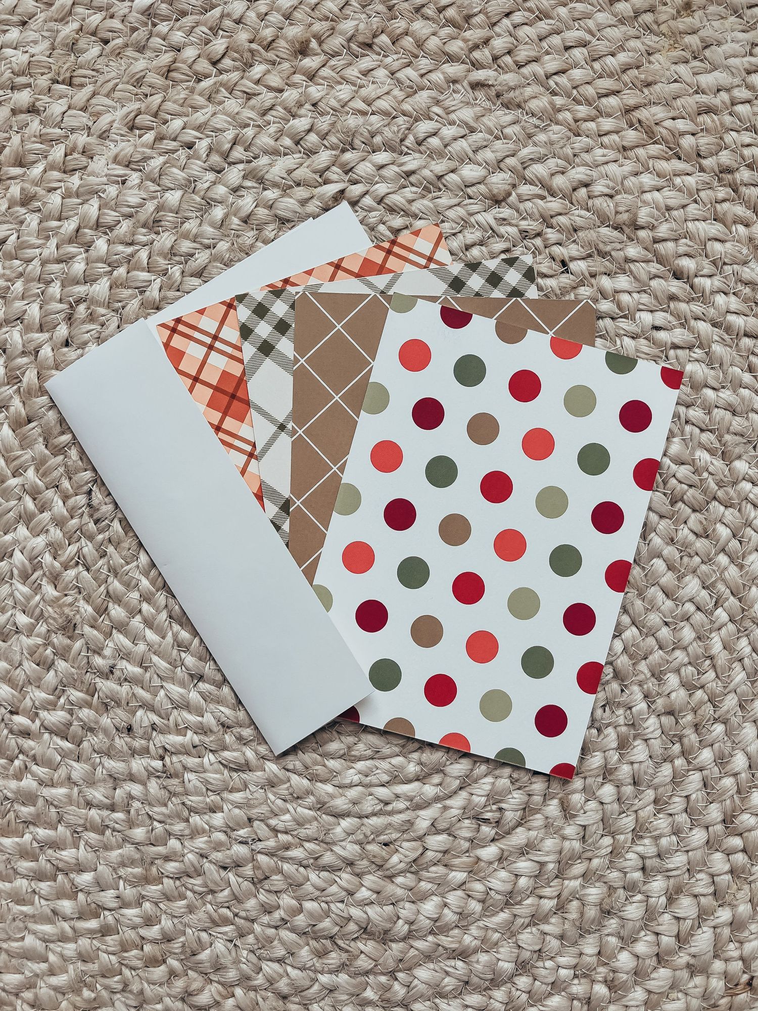 a fan of 5 cards from Basic invite showing the fun designs on the back against a braided rug