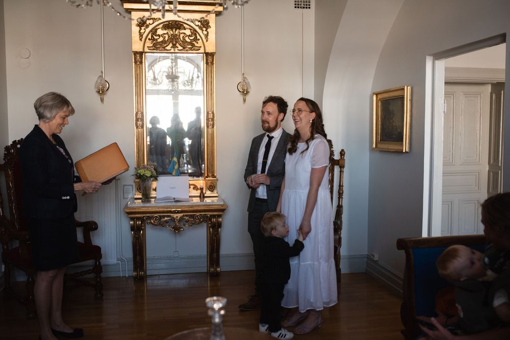 Small gathering in an elegant room with gold-framed mirror and white walls.