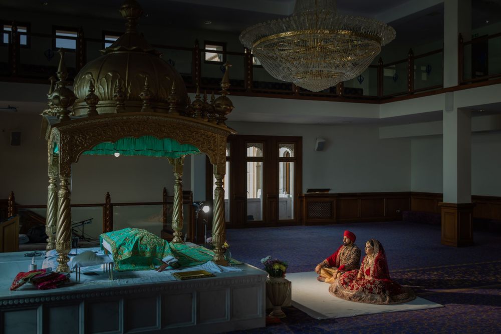 A dramatic scene in a dimly lit hall with colorful traditional outfits and decorative architecture.