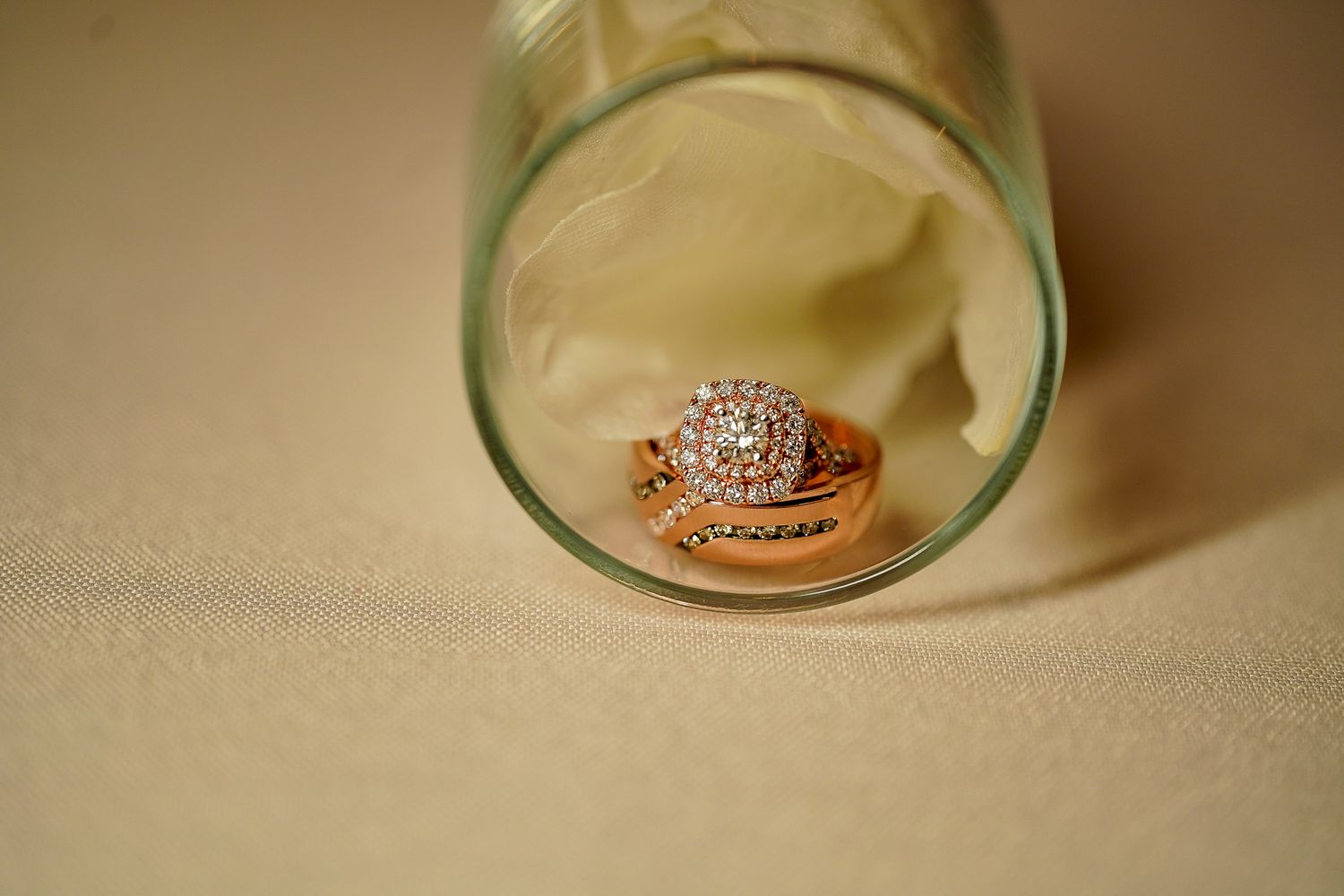 Elegant diamond wedding ring set photographed on turquoise glass surface.