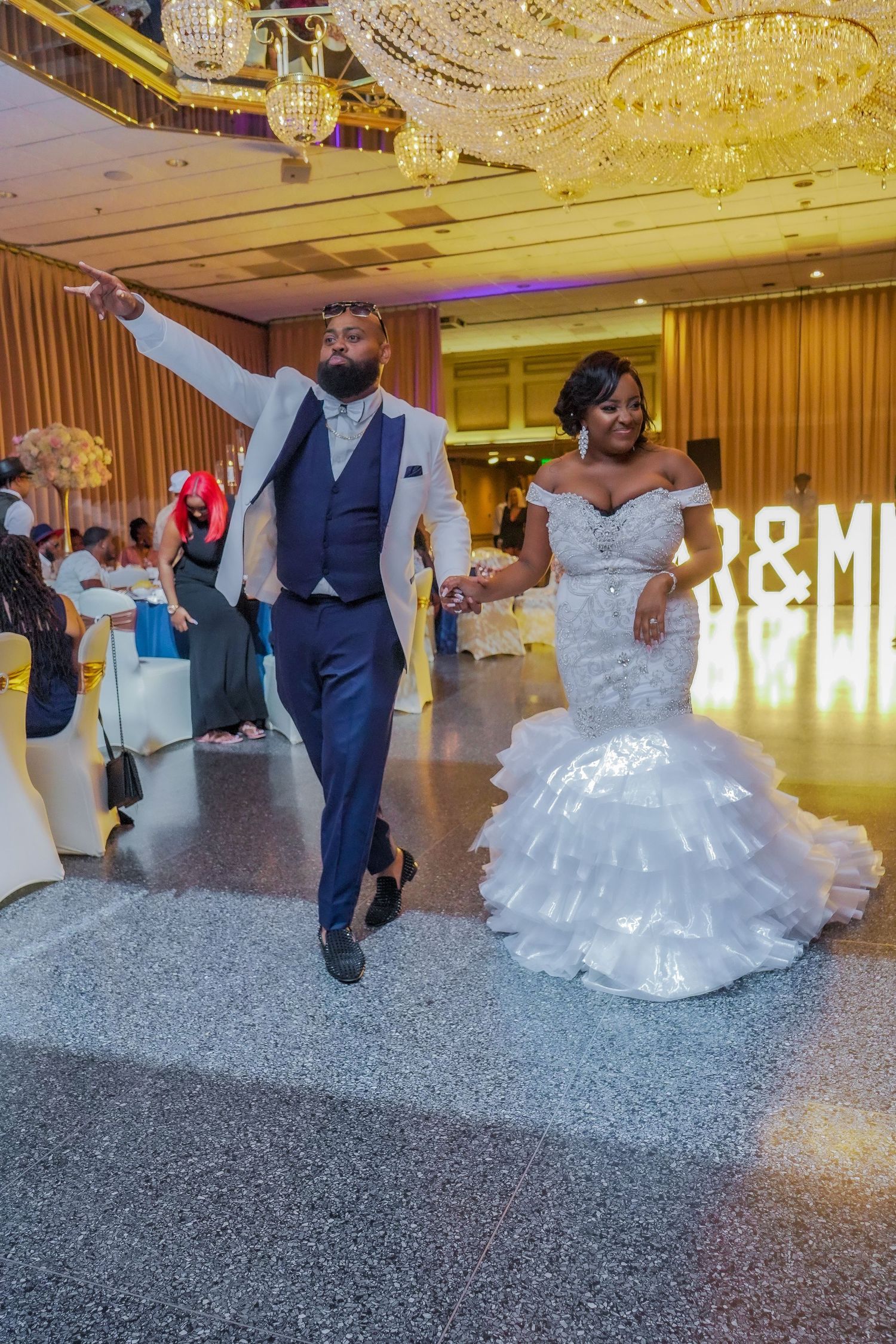Wedding couple dancing on a sparkly floor under crystal chandeliers at their reception venue.