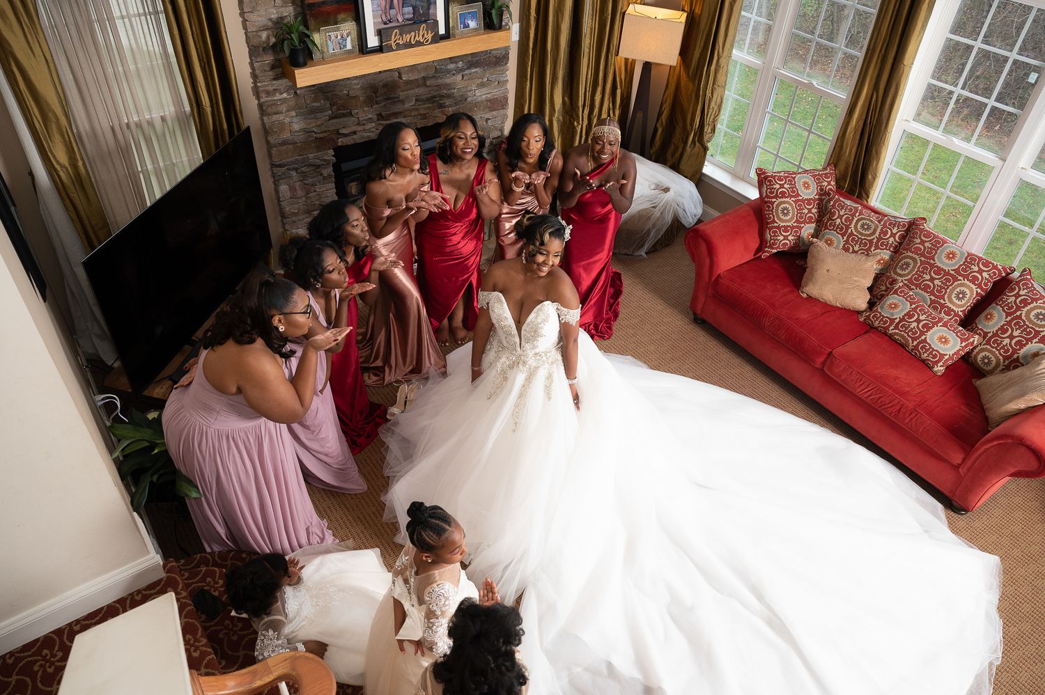 Overhead view of a wedding party gathered around the bride in a beautiful living room setting.