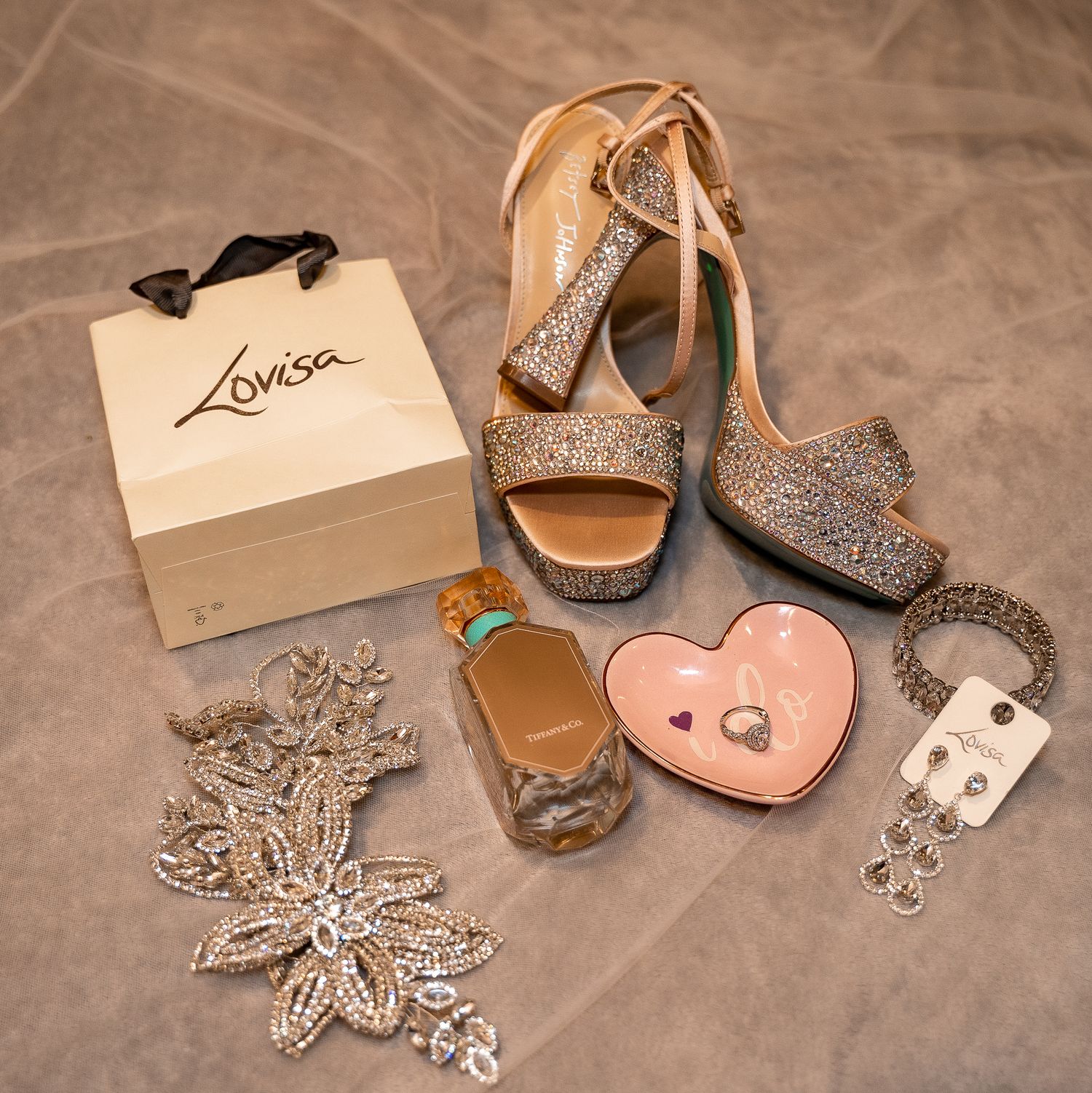 Wedding accessories including sparkly shoes, jewelry and a pink heart-shaped trinket box.
