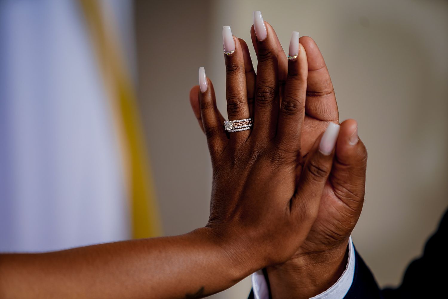 Close up of hands during an emotional wedding ceremony moment.