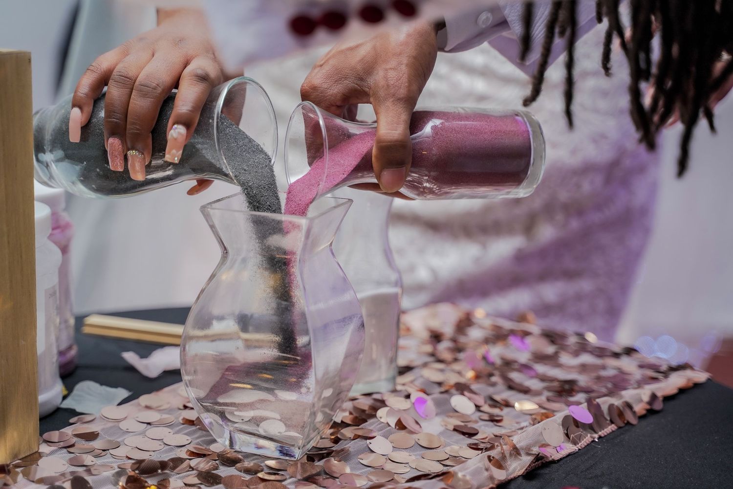 Pouring champagne into glasses with rose petals scattered on the table.