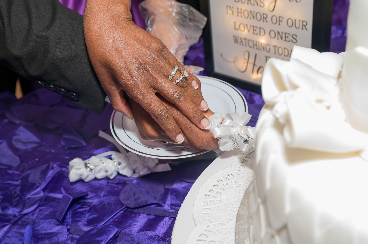 Wedding ceremony details showing hands pouring unity sand into a decorative container.