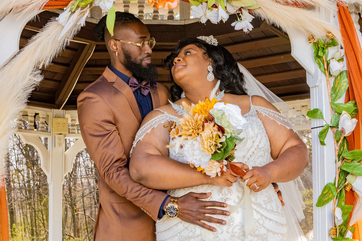 Wedding couple sharing romantic moments under floral arch decorations during their ceremony.