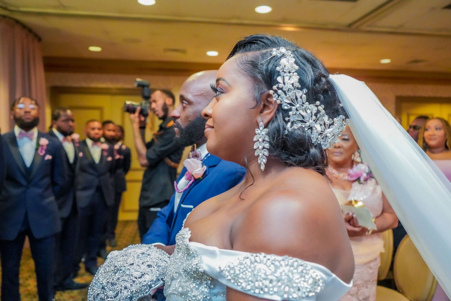 Wedding reception celebration with guests in an elegant ballroom setting.