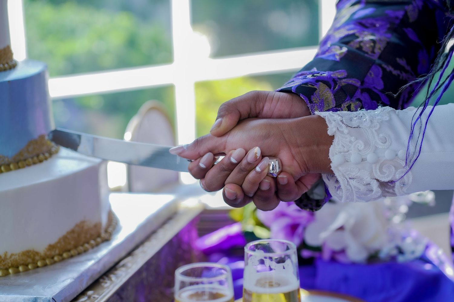 Wedding reception table settings with purple decor and floral arrangements.