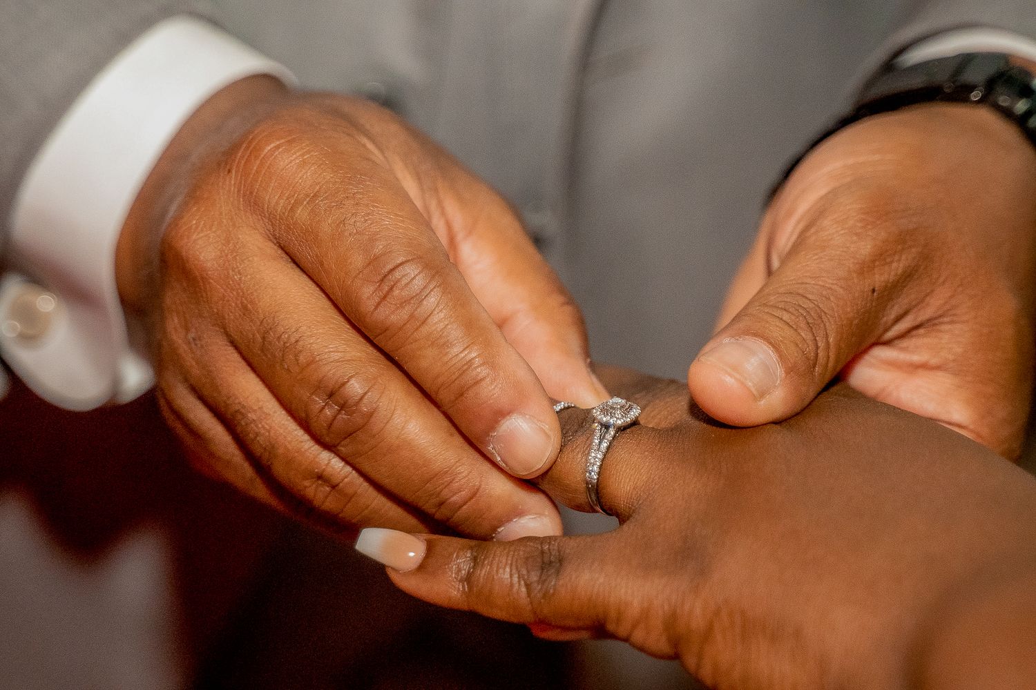 Close-up detail shot of engagement ring and hands during wedding preparations.