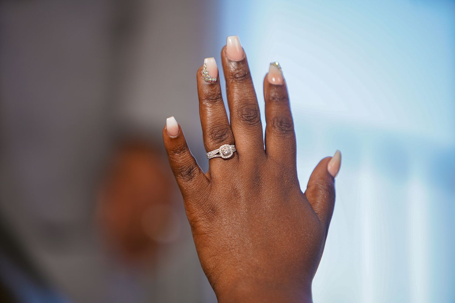 Close-up of wedding rings and jewelry against a blue background.