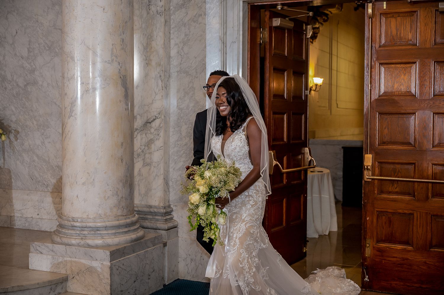 Elegant wedding venue featuring marble columns and wooden doors creating a classic ambiance.