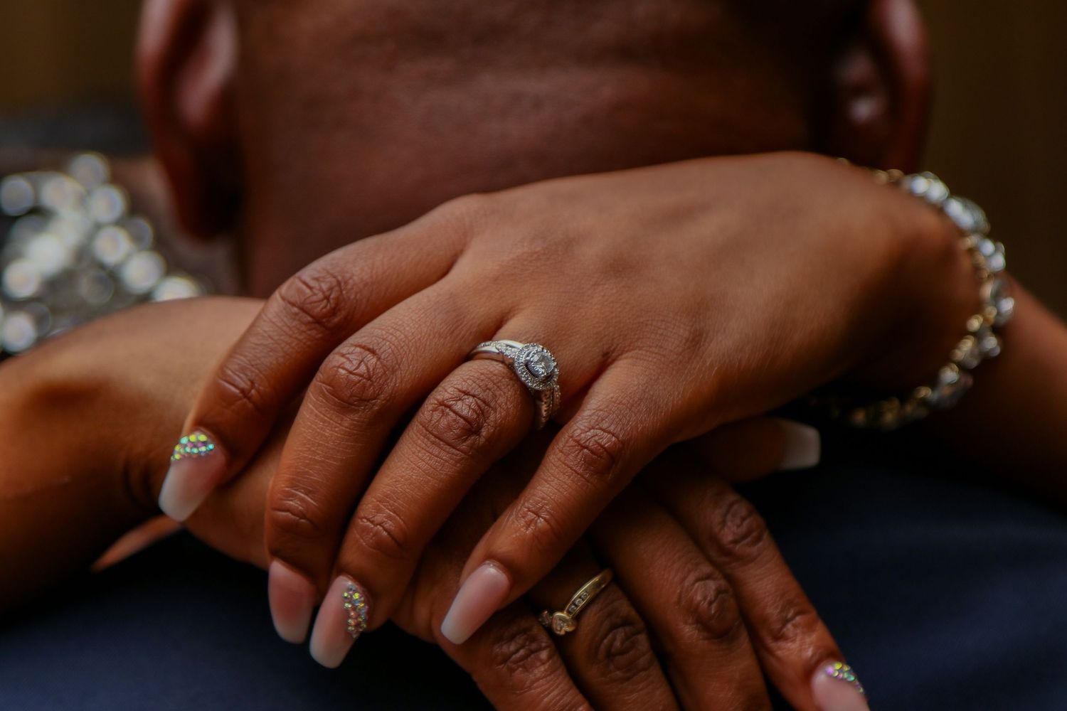 Close-up of hands showing elegant wedding rings and jewelry.