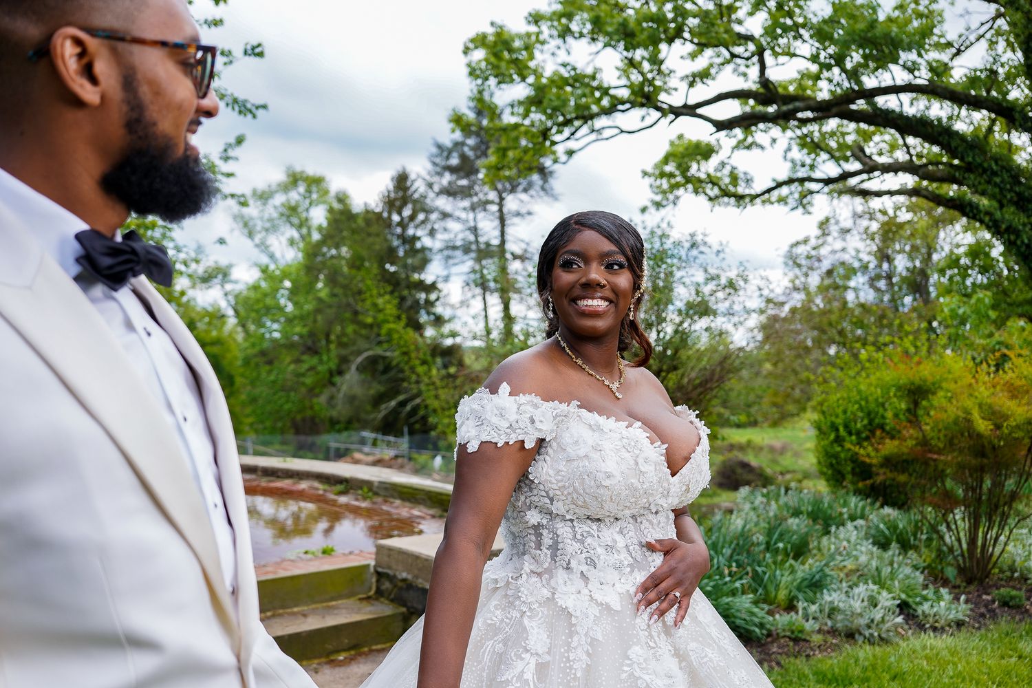 Close-up wedding portraits of couple in white attire against garden scenery.