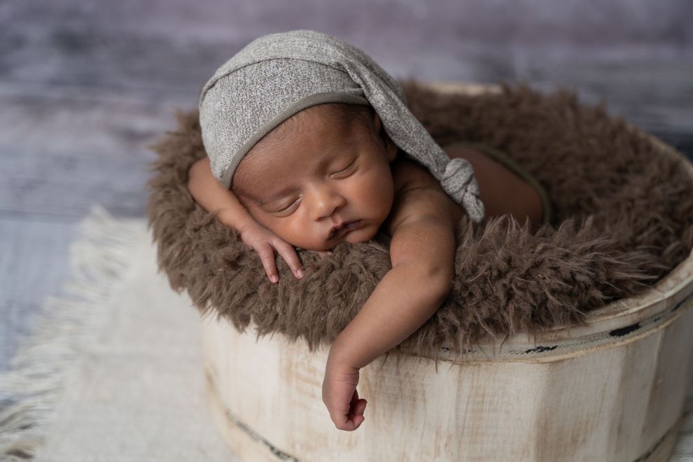 Baby posed and sleeping in a bucket in a Centerville Ohio photography studio